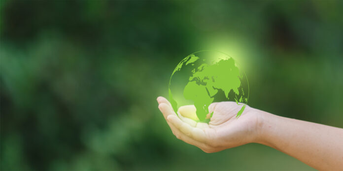 human-hand-holding-a-green-earth-globe-on-blurred-nature-background-save-the-world-concept